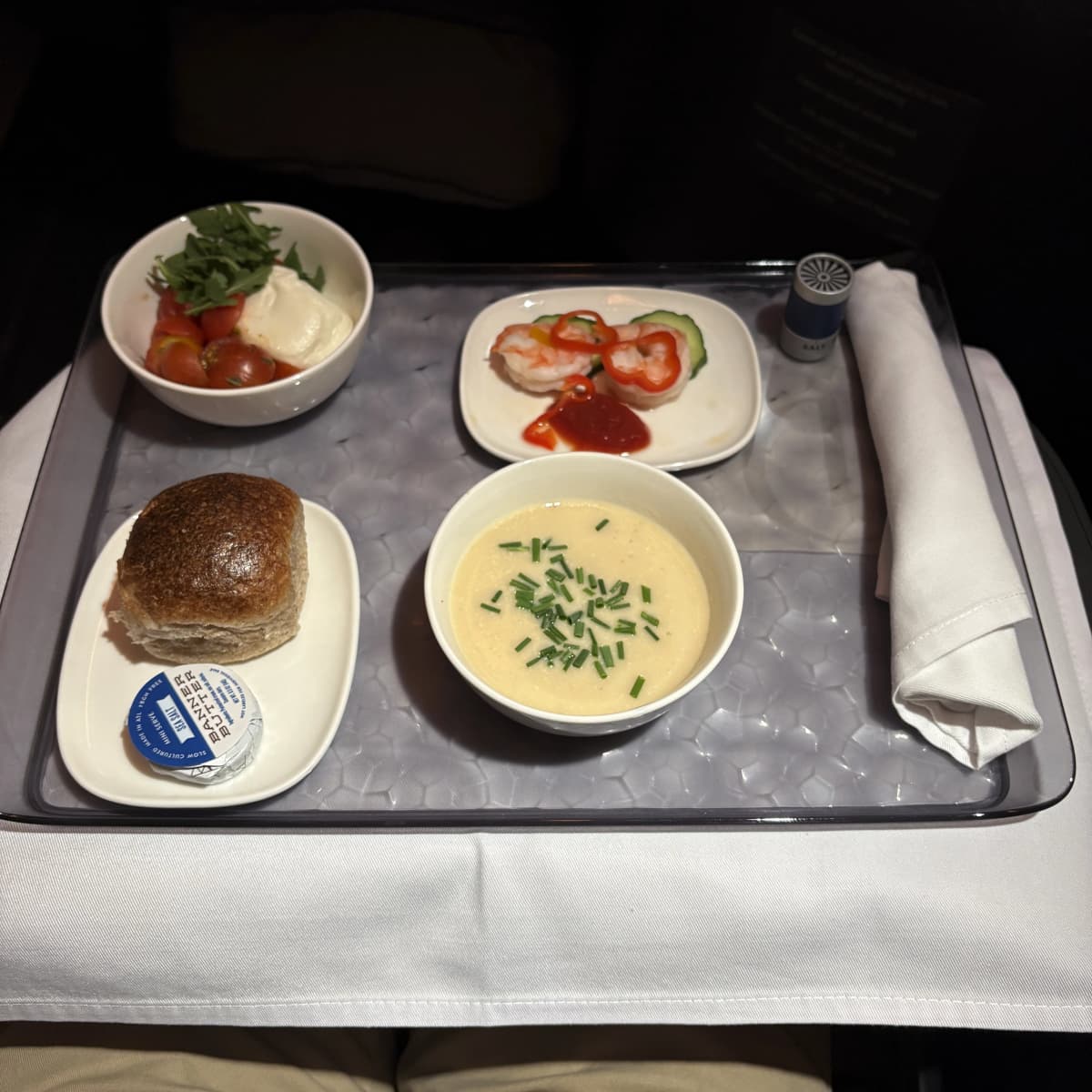 Delta One business class appetizer featuring shrimp and warm bread roll
