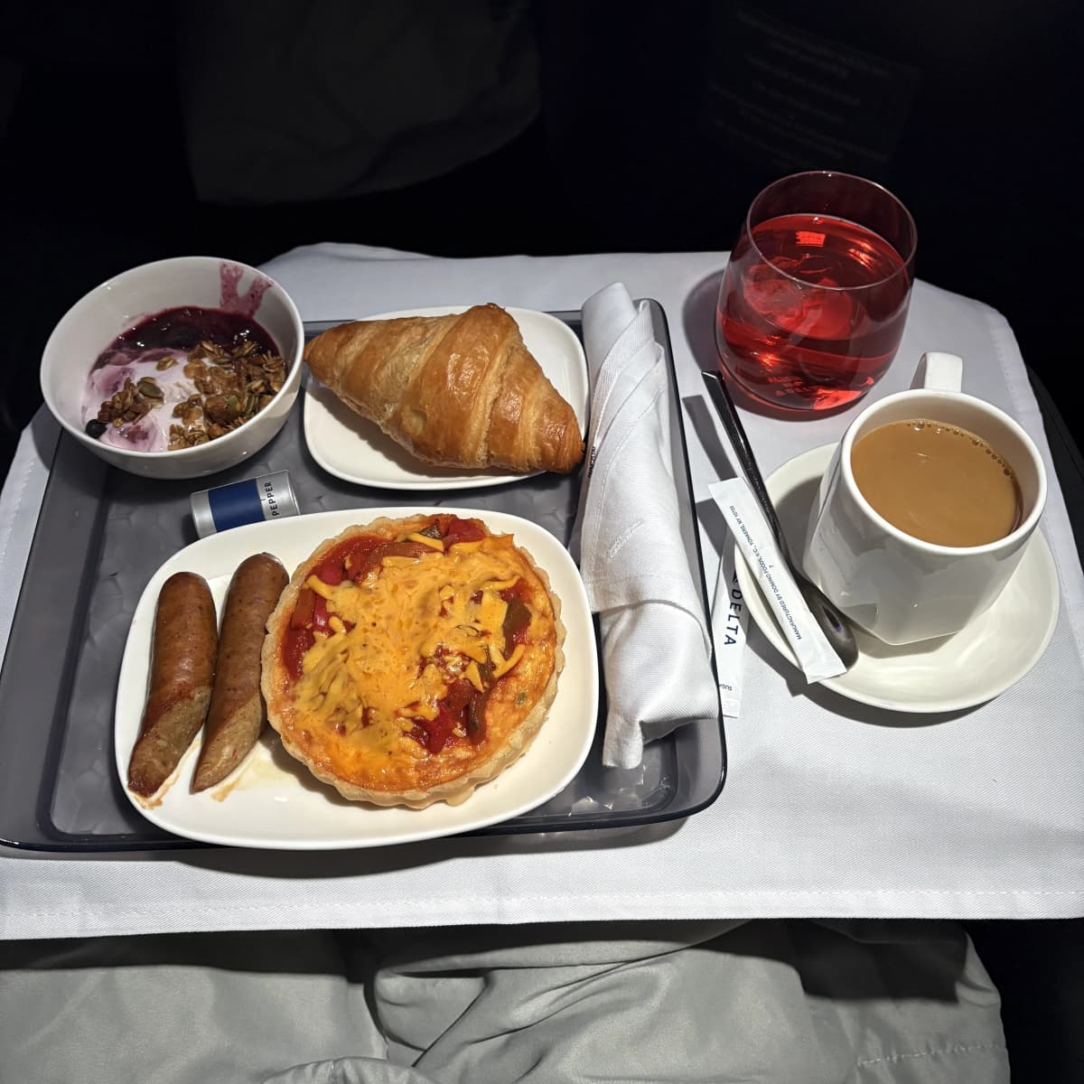 Delta One breakfast service featuring quiche and fresh fruit before landing