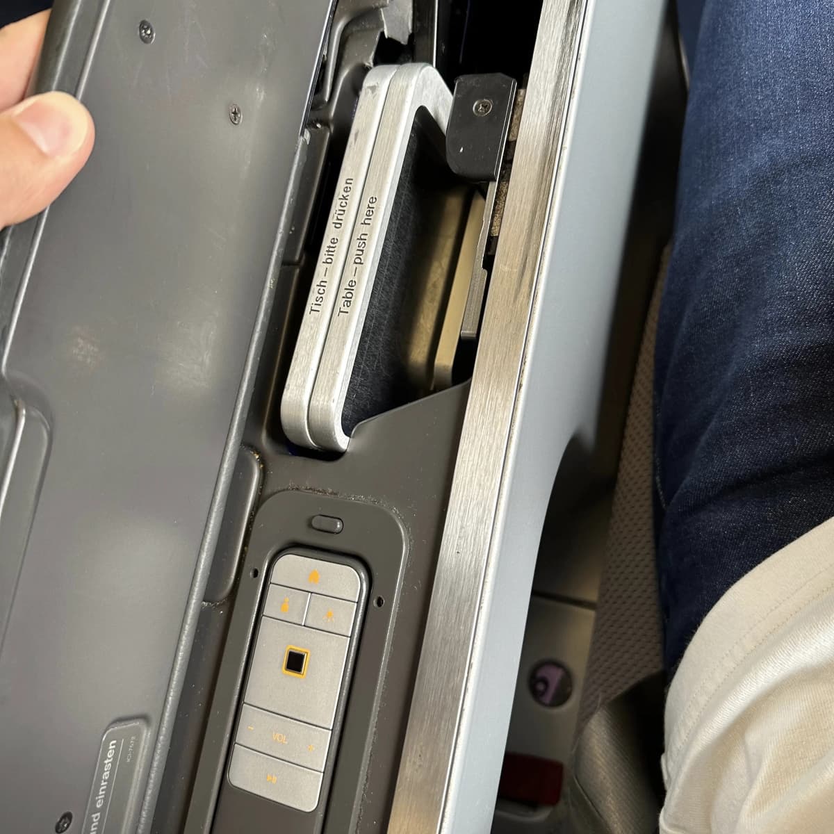 Lufthansa Airlines business class tray table and TV remote storage.